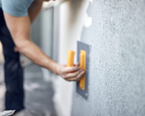 Man working on a house facade.